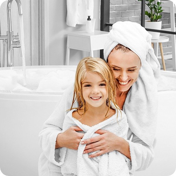 A parent and child wrapped in towels after a warm bath